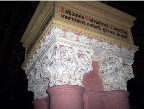 Над капителями колонн надписи, которые гласят, что «здесь стоят первенцы типографского искусства», и что «имя Иоганна Гутенберга — изобретателя книгопечатания останется жить вечно».