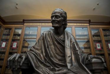 Бронзовая скульптура Вольтера на фоне шкафов с его библиотекой