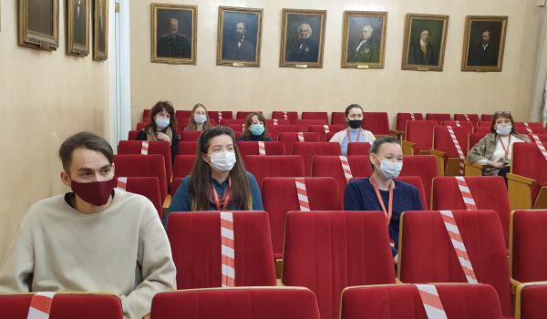 Слушатели заняли места в конференц-зале, соблюдая дистанцию и меры предосторожности против COVID.