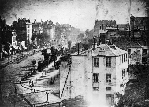 Париж. Вид на бульвар дю Тампль. Дагеротип. Луи Дагер, 1838 год. На снимке запечатлено первое фотографическое изображение человека – фигура мужчины возле чистильщика обуви