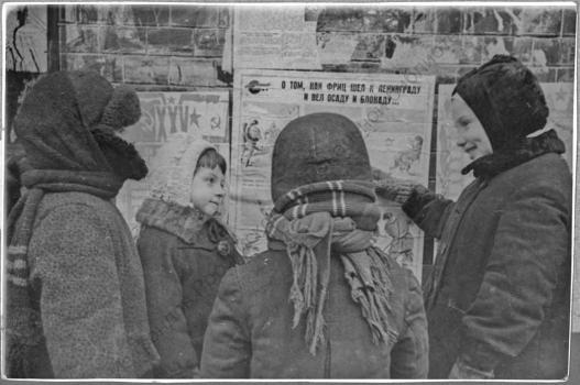 Маленькие ленинградцы рассматривают праздничные плакаты в день XXV годовщины Красной армии : [фотография].